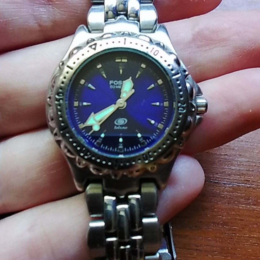 Fossil watch with blue face and extra links.